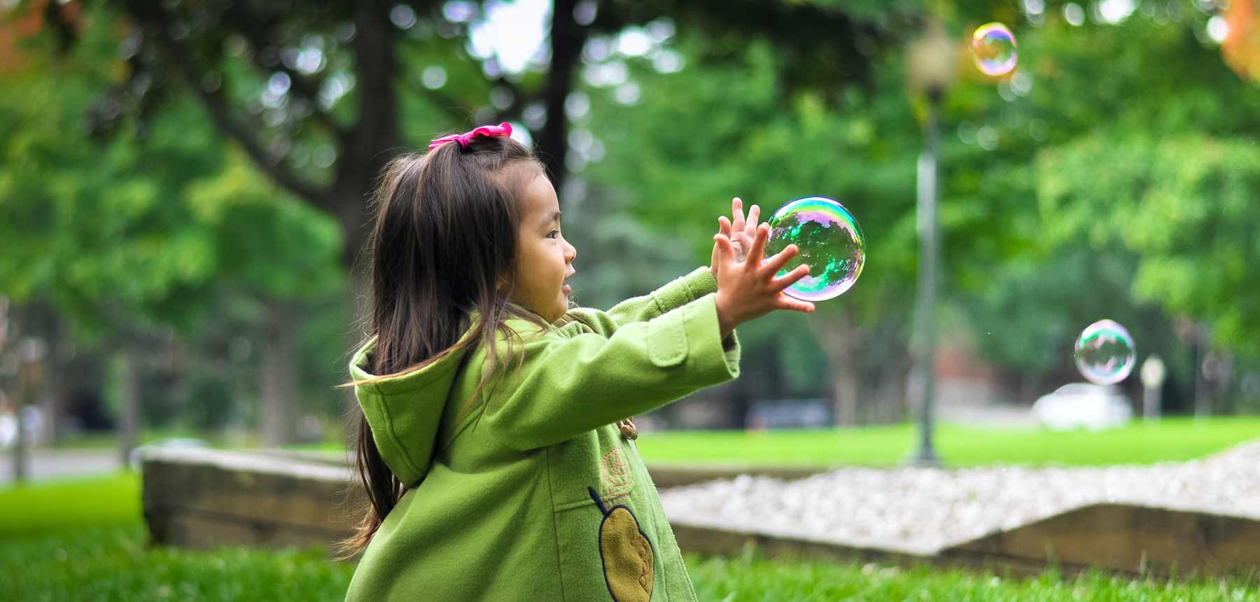 Kleines Mädchen spielt mit Seifenblasen