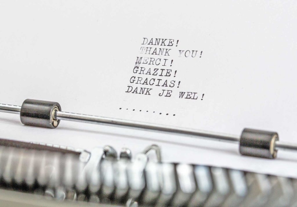 Blatt in Schreibmaschine mit dem Wort Dank in sechs Sprachen