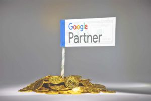 Ein Haufen Goldmünzen, in dem eine kleine Fahne steckt, auf der "Google Partner" steht