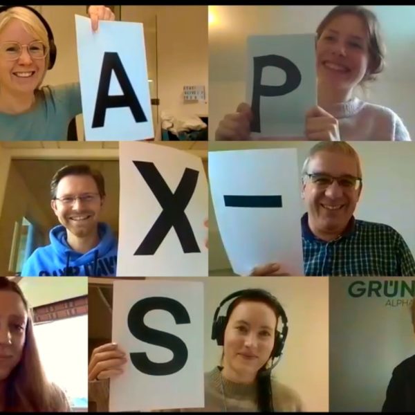 Alle GRÜN alpha MitarbeiterInnen halten im Zoom-Call je einen Buchstaben hoch, sodass "Happy X-Mas" entsteht
