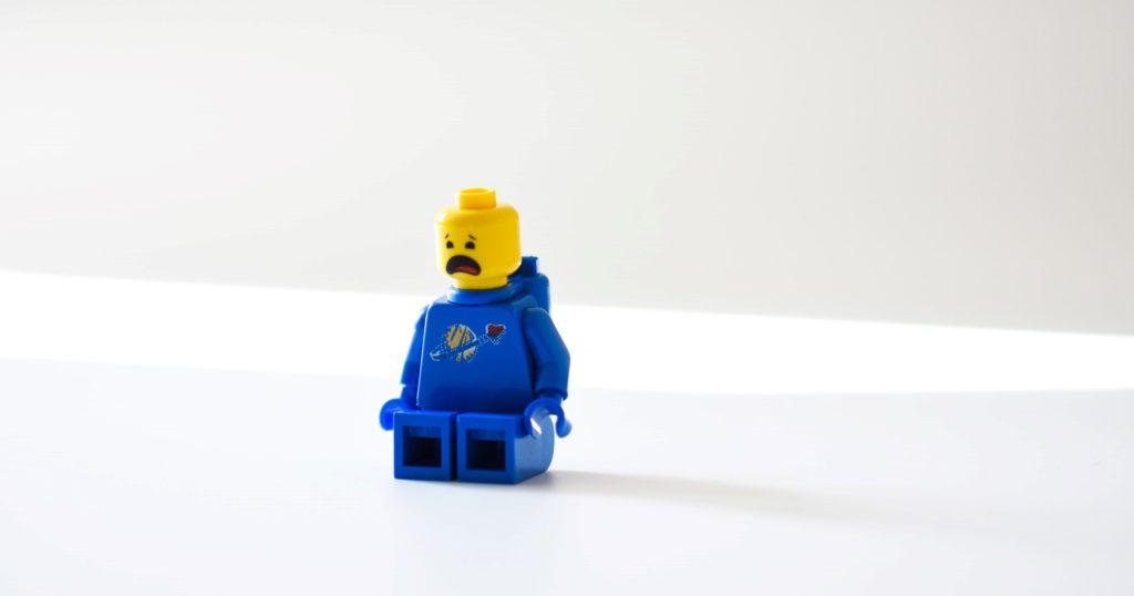 Auf einem weißen Tisch steht eine blaue Legofigur, bereit für die Spendensammlung.