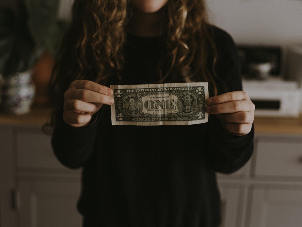 Eine Frau präsentiert einen Ein-Dollar-Schein für Spendenzwecke.