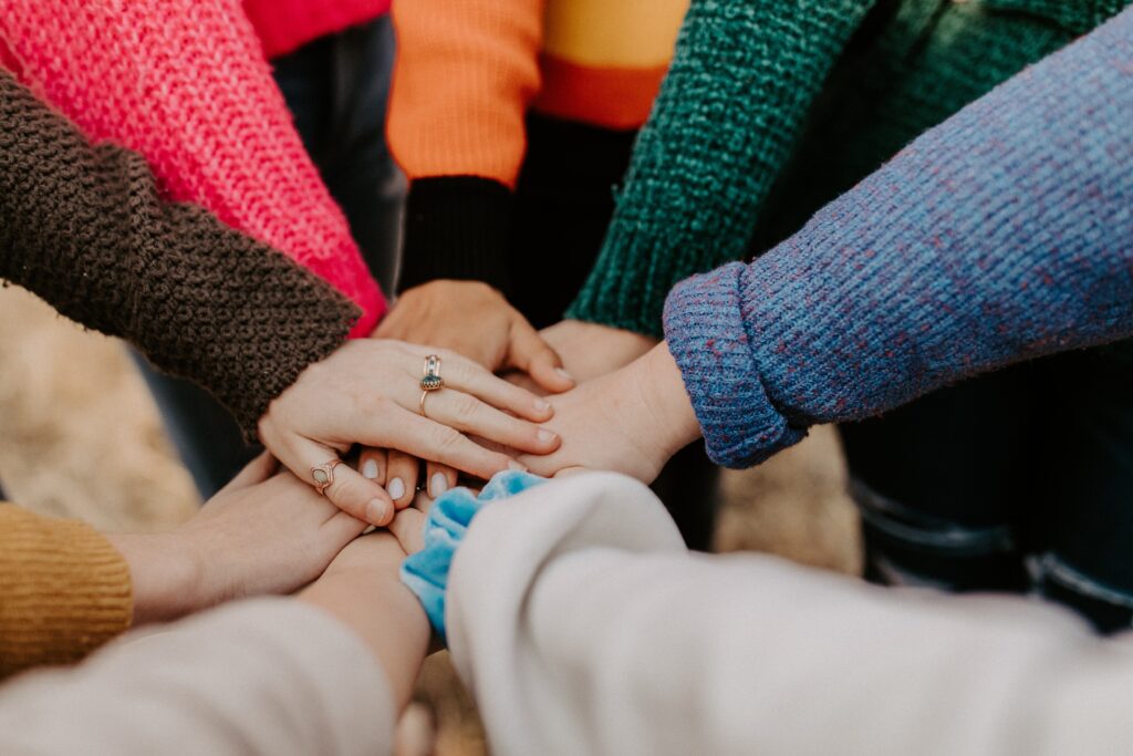 Eine Gruppe von Menschen, die an einer Spendenaktion teilnehmen und ihre Hände im Kreis zusammenlegen.